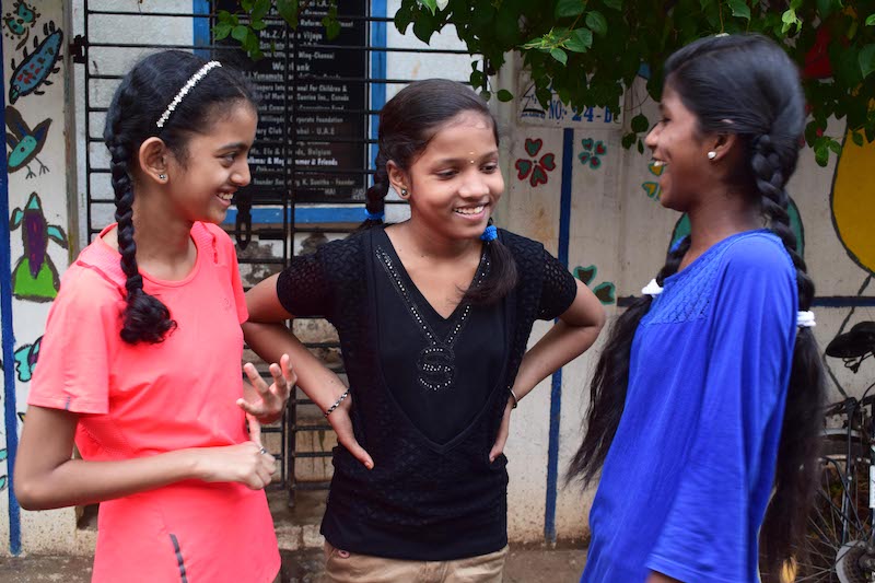 Technovation Girls 2019 Team Social Relay won first place junior division at World Pitch – the three young girls who are part of social relay stand in a semi-circle laughing and talking