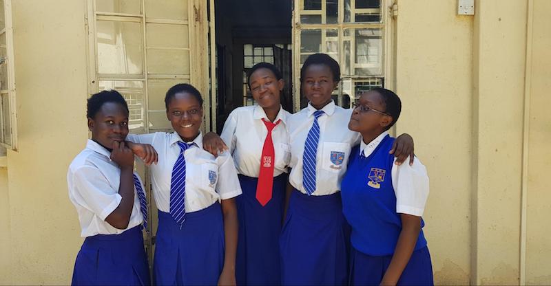 Technovation Girls: Global Problem Solvers Team Restorers: 5 girls in school uniforms pose in front of a school